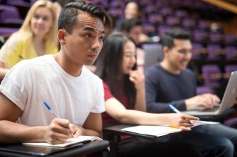 Students with laptops in lecture theatre class