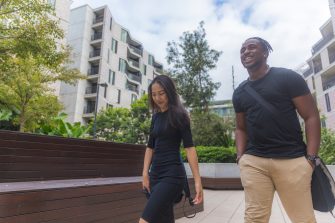 Male and female student walking outside near on campus accommodation