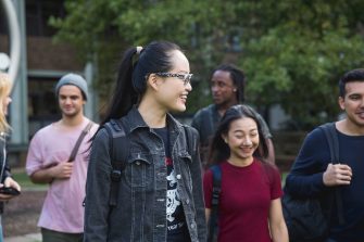 Students walking and talking on campus green