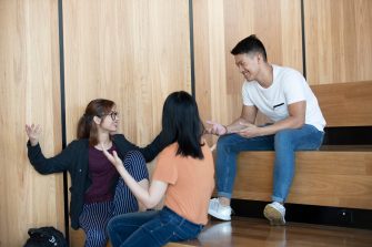 Students sitting on brown wooden steps
