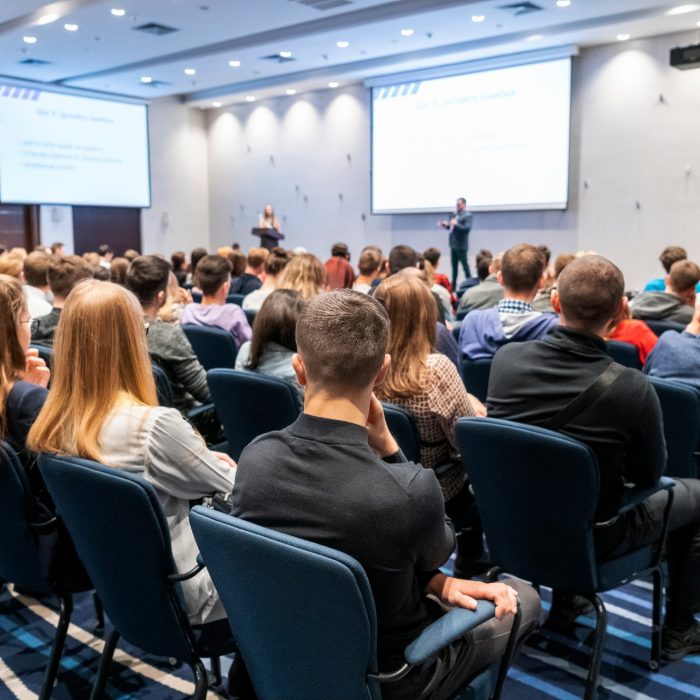 Image of a conference that takes place in a large conference room, workshop for young professionals, training in a large conference room, adult training