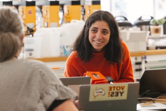 Smiling student at the Diversity Festival 2023 Laser Cut Jewellery and Badge Making Workshop