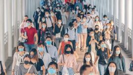 Shot of lots of students walking down a corridor all wearing masks during covid