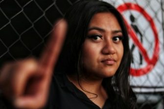 Woman holding her finger up to say no