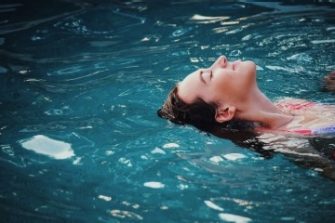 Woman relaxed and floating on her back in a pool