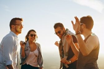 4 friends laughing and dancing