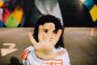 Young woman with her hand up to say stop