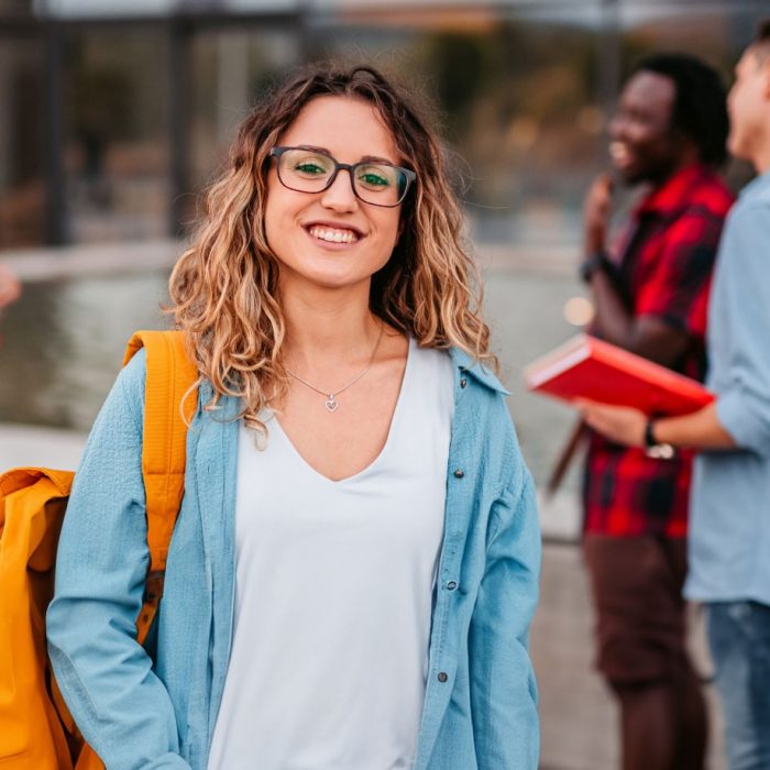 Photo of happy student with other students out of focus in the background