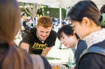 Diversified staff talking with students on campus