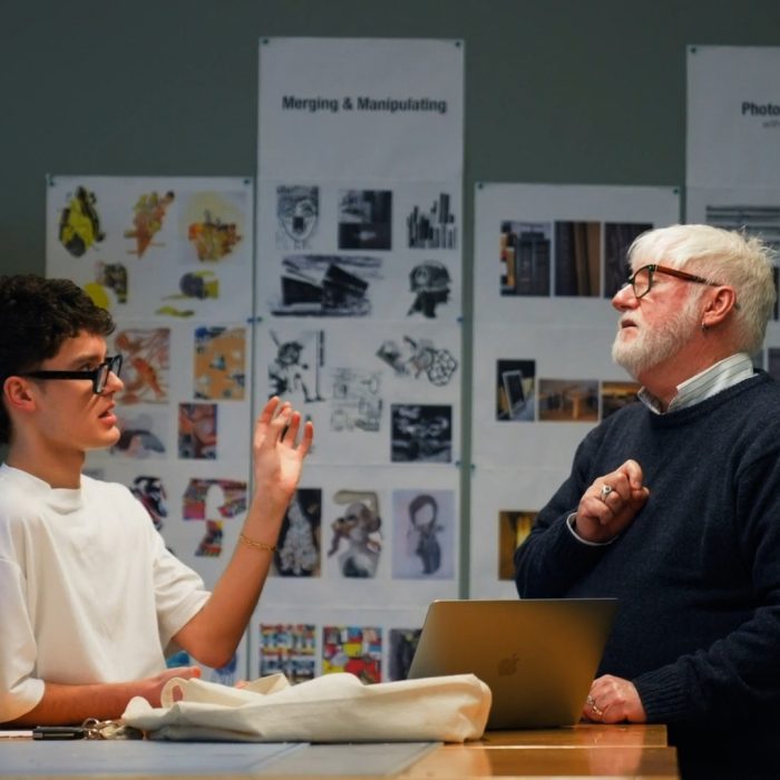 Diversified staff talking with students in classroom