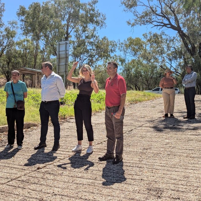 Six people are standing on a boat ramp in rural NSW