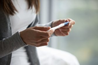 A woman looks at the results of a pregnancy test