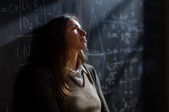 woman leaning on black board