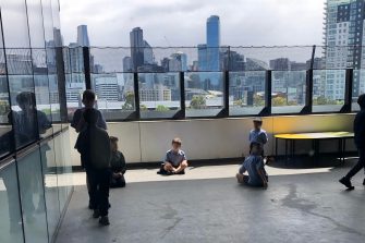 school children outside overlooking city