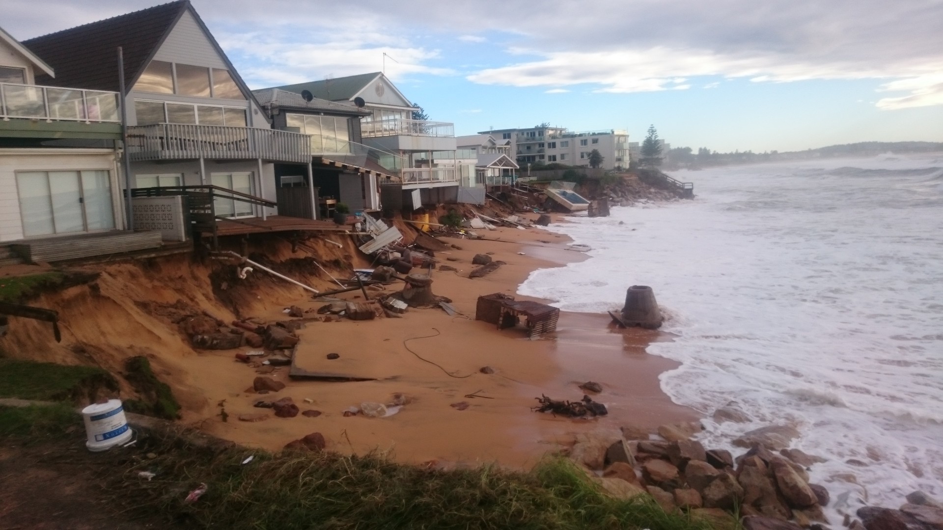 Damaged houses and belongings strewn on beach after the 2016 coastal superstorm