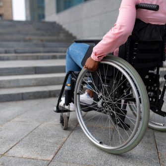 Person in wheelchair facing a staircase