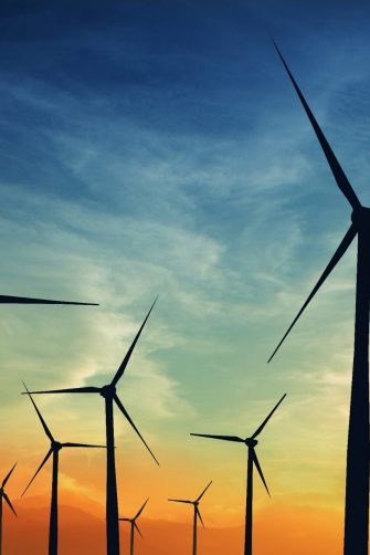 concept idea eco power energy. wind turbine on hill with sunset