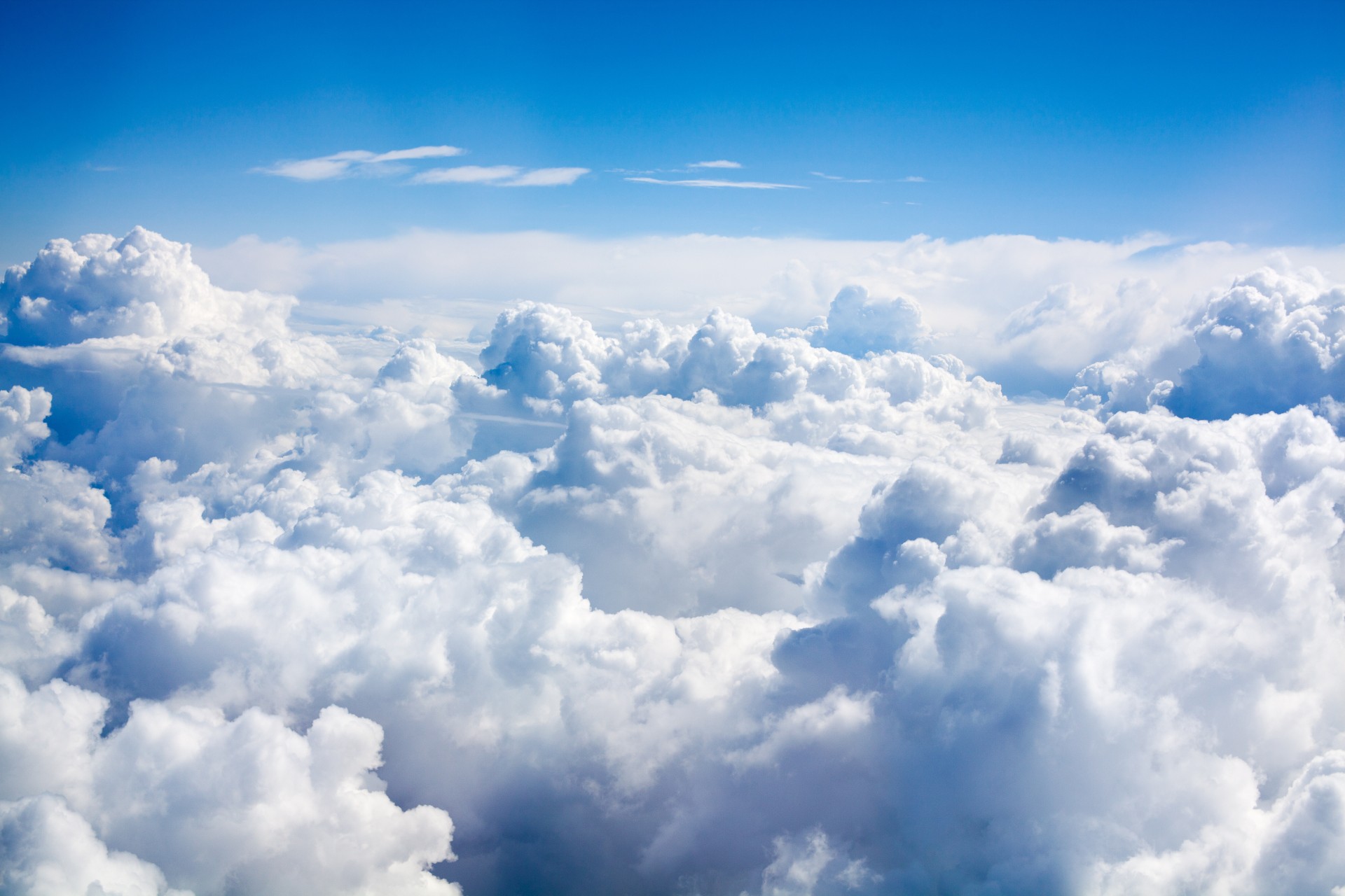 White clouds on blue sky background close up, cumulus clouds high in azure skies, beautiful aerial cloudscape view from above, sunny heaven landscape, bright cloudy sky view from airplane, copy space