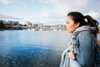 Young woman leaning against barrier, taking in view, Yaletown Ferrydock, Vancouver, Canada