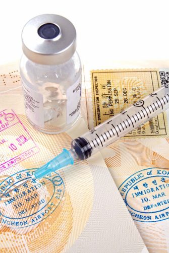 stamped passport pages with medical vaccination equipment  on a white background 