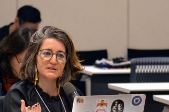 Sherine Al Shallah gestures with her hand while talking from behind a laptop computer