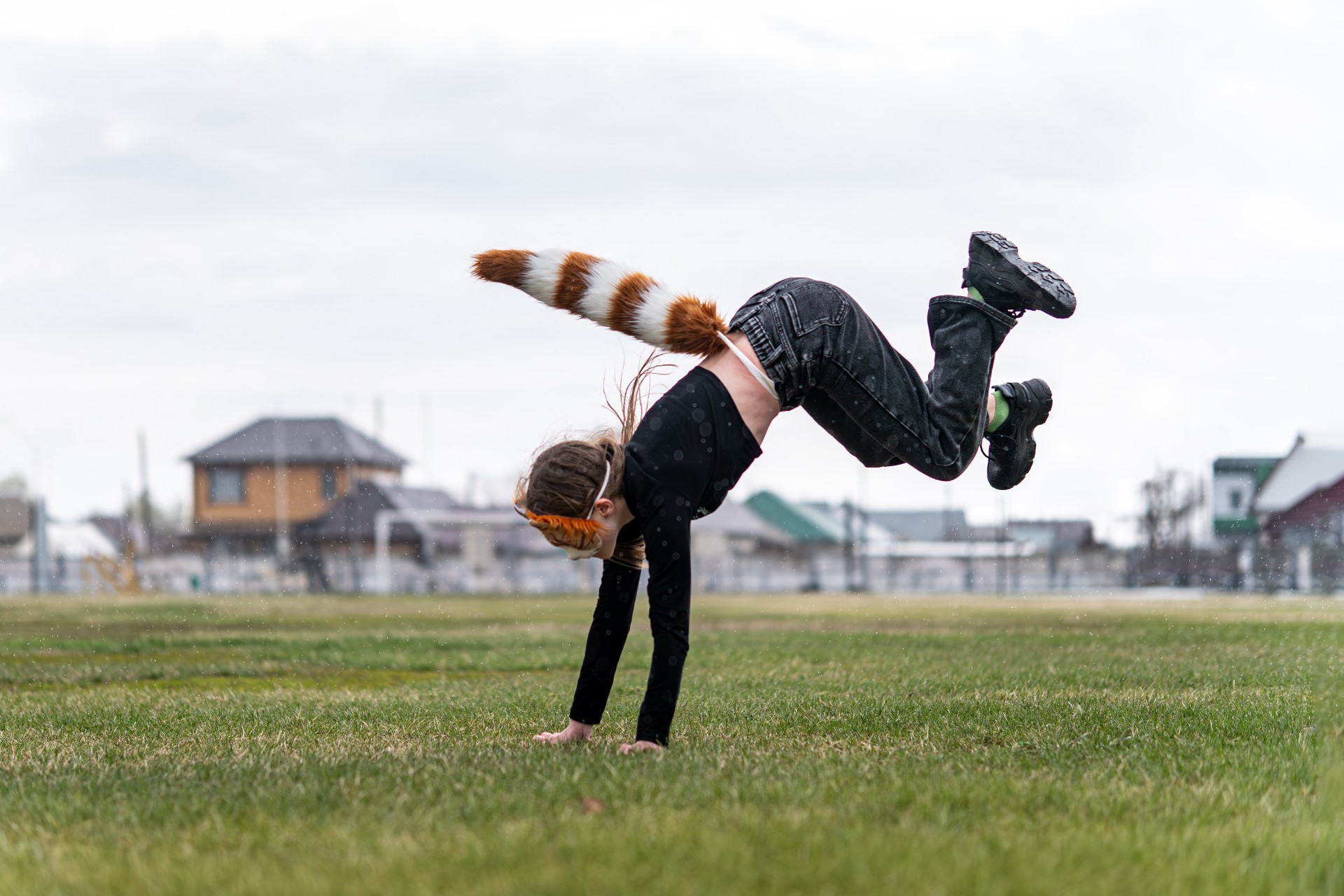 Teenage girl with cat mask and gloves doing Quadrobics. A girl in a cat mask Jumps like a cat