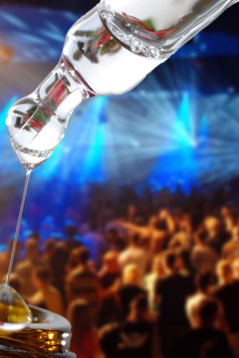 bottle of liquid drug imposed on a background of a rave