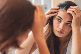 Young woman looking at herself in mirror