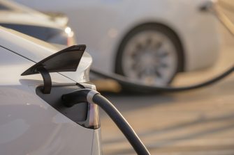 Electric cars charging at charging station outdoors at sunset.