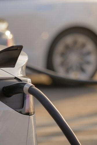 Electric cars charging at charging station outdoors at sunset.