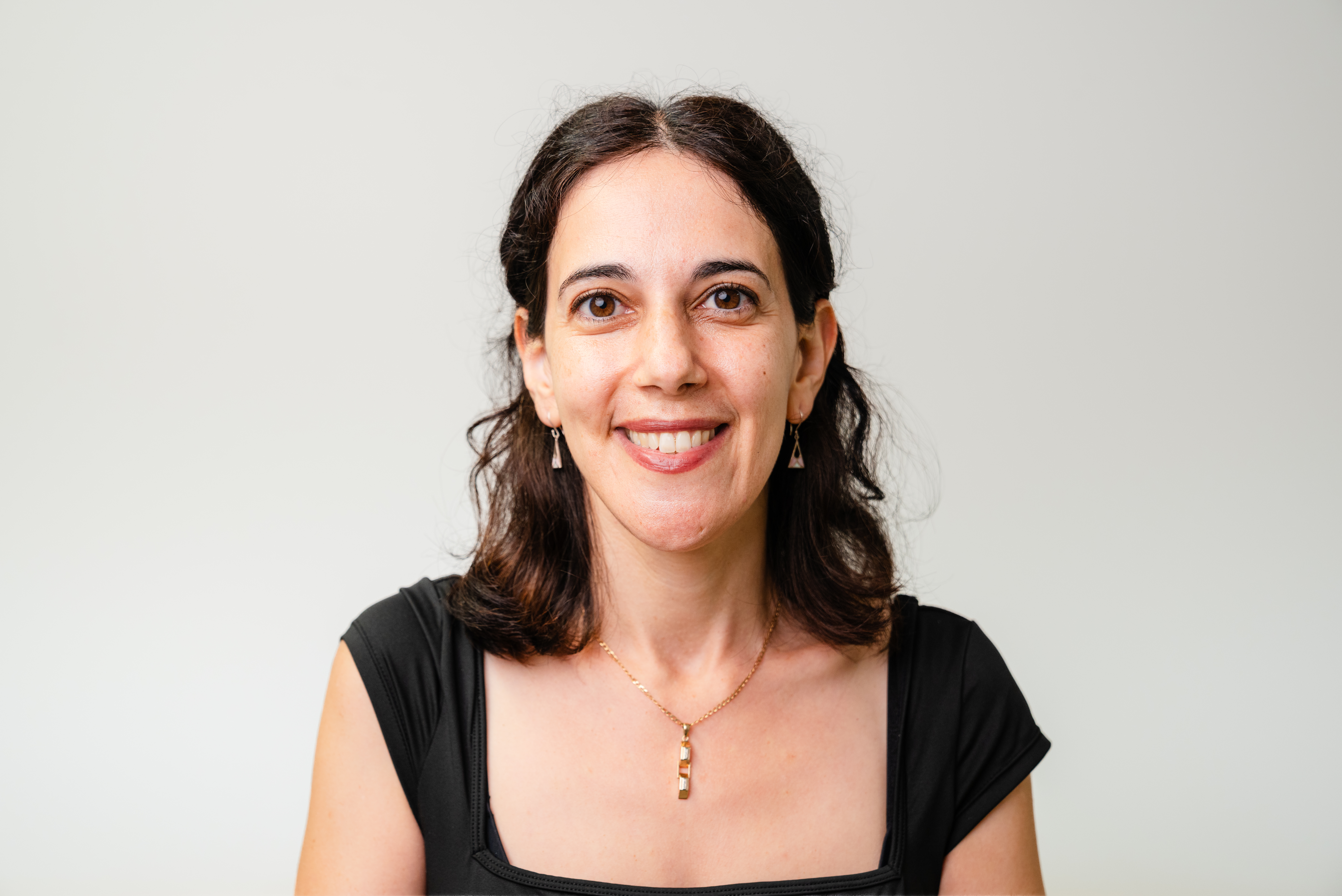 A woman with brown hair smiling.