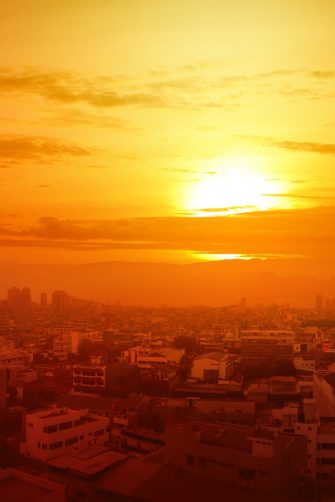 Heatwave on the city with the glowing sun background. Heatwave concept