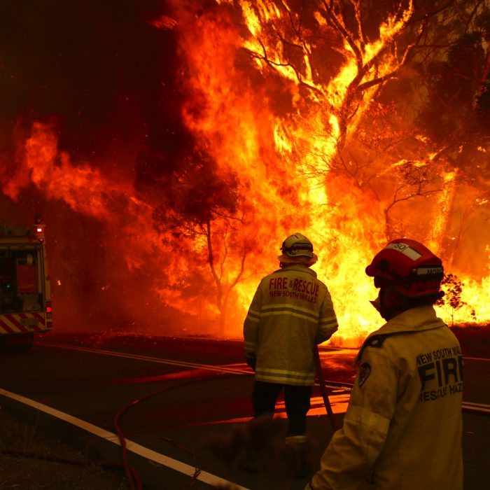 SYDNEY, AUSTRALIA - DECEMBER 19: Fire and Rescue personnel run to move their truck as a bushfire burns next to a major road and homes on the outskirts of the town of Bilpin on December 19, 2019 in Sydney, Australia. NSW Premier Gladys Berejiklian has declared a state of emergency for the next seven days with ongoing dangerous fire conditions and almost 100 bushfires burning across the state. It's the second state of emergency declared in NSW since the start of the bushfire season.  (Photo by David Gray/Getty Images)