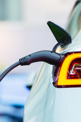 Close up of the Hybrid car electric charger station with power supply plugged into an electric car being charged.