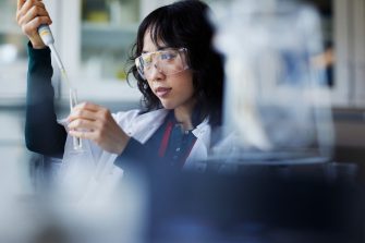 Woman using a pipette and test tube in a lab