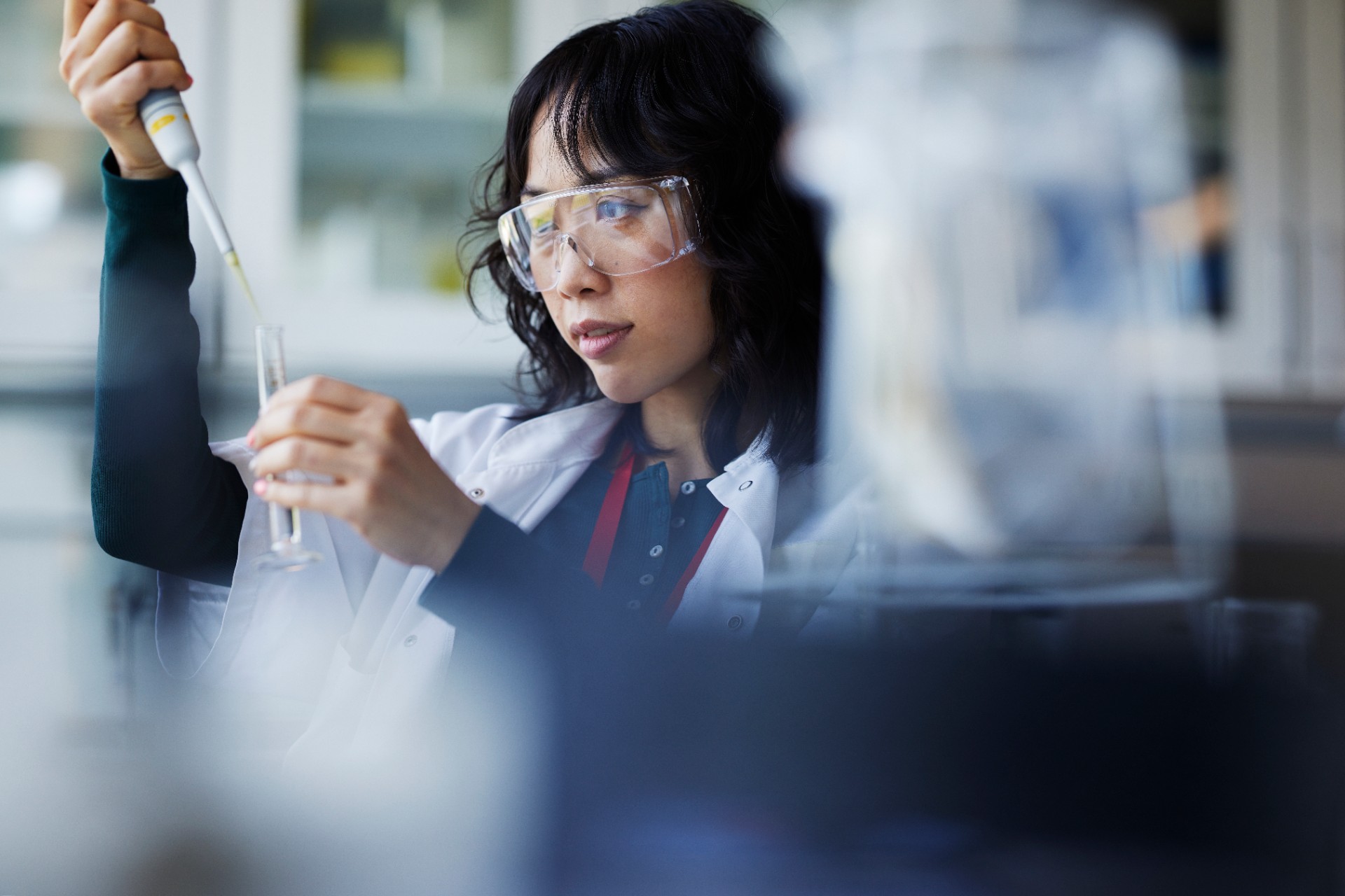 Woman using a pipette and test tube in a lab