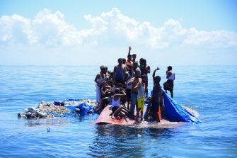 Rohingya refugees wait to be rescued from the hull of their capsized boat as a National Search and Rescue Agency (BASARNAS) vessel approaches in waters some 29 kilometers off west Aceh on March 21, 2024. Photo by ZAHLUL AKBAR/AFP via Getty Images