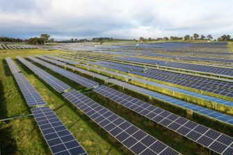 Aerial of a solar panel farm in rural area at sunrise