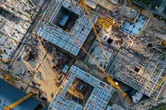 A construction worker pouring a wet concret at road construction site