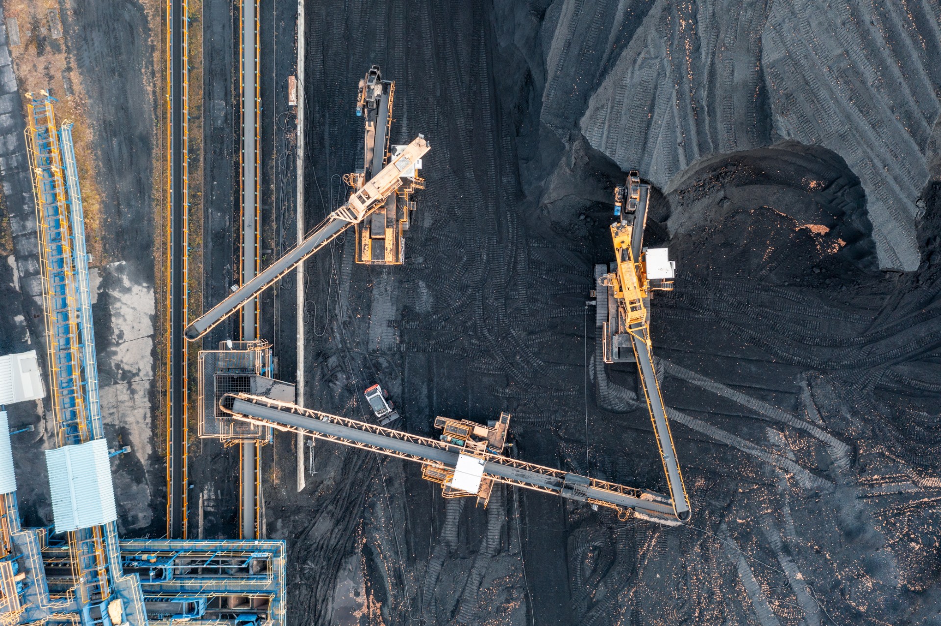 Territory of the coal terminal with coal dumps and a regenerator. loading and unloading of coal by excavators and belt conveyors. coal reserves at thermal power plants. View from above