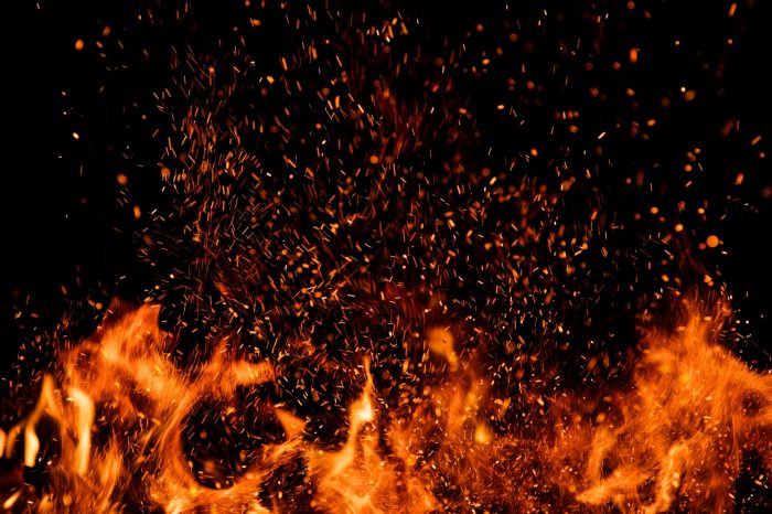 Detail of fire sparks isolated on black background. Abstract flaming background
