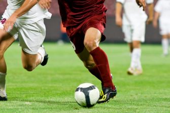 Soccer players legs as they run for the ball.