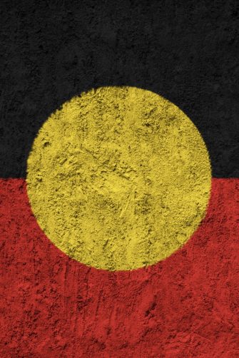 Australian aboriginal flag attached to baby stroller at indigenous community ritual smoking ceremony rite