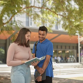 Two students smiling and talking outside the Bioscience building UNSW,  Kensigton campus.