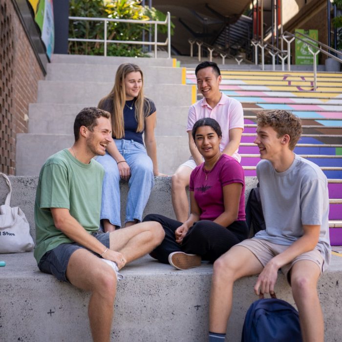 A group of students sitting on the Basser Rainbow Steps 