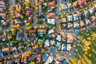 An aerial photograph showcasing a residential neighborhood in Australia, highlighted by vibrant autumn foliage and a variety of homes.