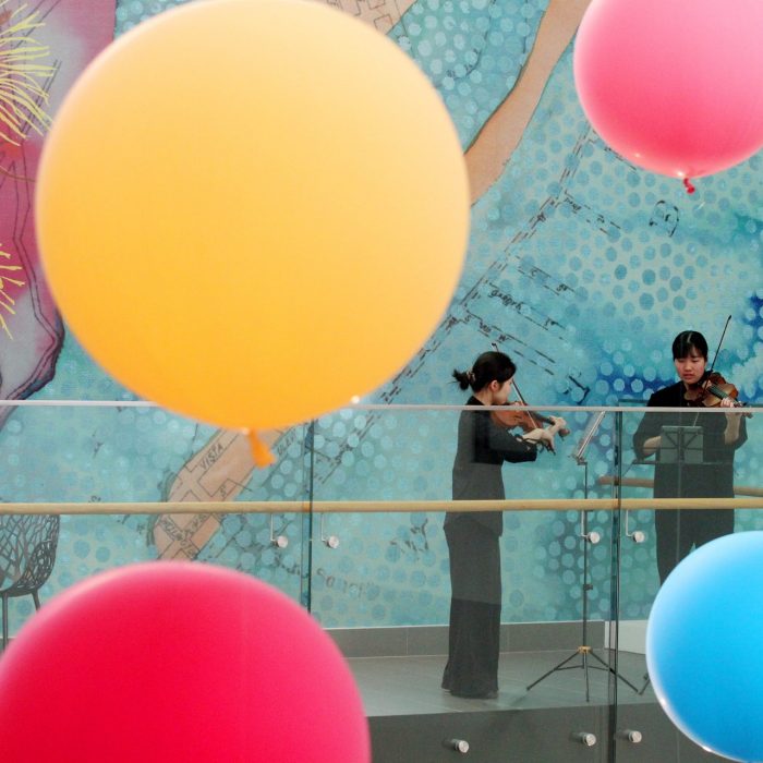 Two violinists performing on balcony in St George Hospital during Festival of Care