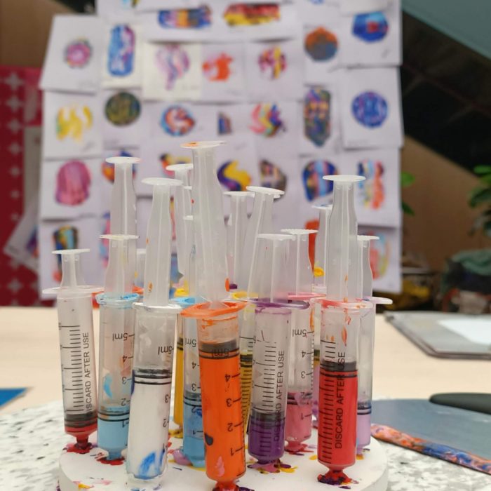 Multiple syringes filled with colourful paint