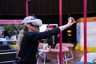 A lady wearing a VR headset at the Unconvention exhibition in the UNSW Roundhouse