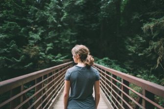 Young woman crossing footbridge